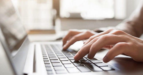 Hands on a laptop typing